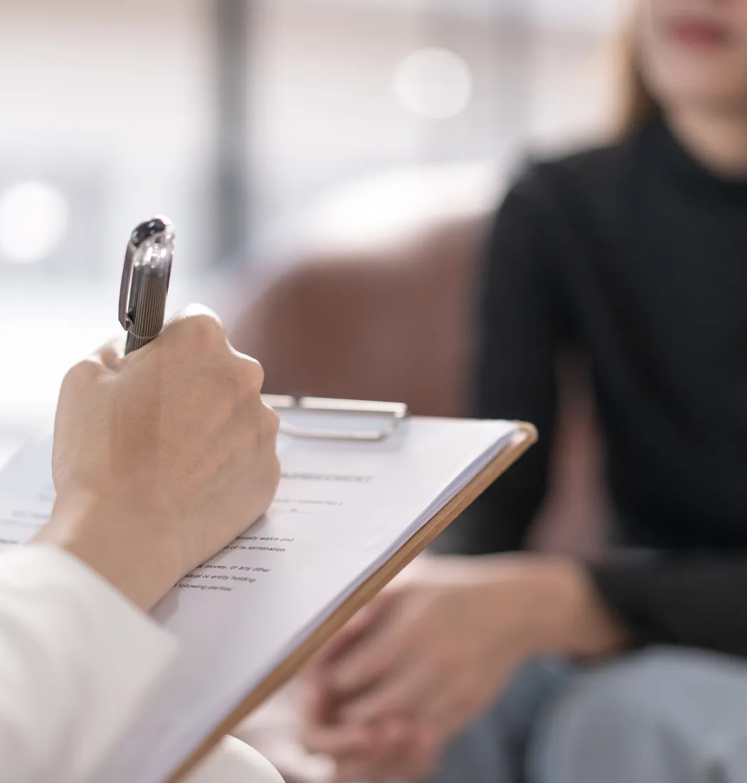 Hipnoterapija seansa - terapeut drži beleške tokom razgovora sa pacijentom