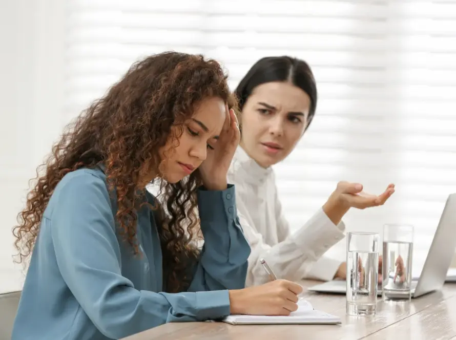 Dve žene u poslovnom okruženju diskutuju o emocionalnom konfliktu - hipnoterapija i kontrola emocija